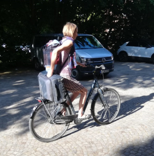 Lena Domröse transportiert einen Koffer auf dem Gepäckträger ihres Fahrrads