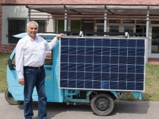 Mann steht neben Piaggo Ape, die mit Solarzellen ausgestattet ist